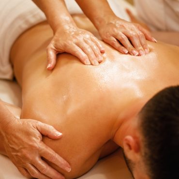 Close-up of four hands back massage.